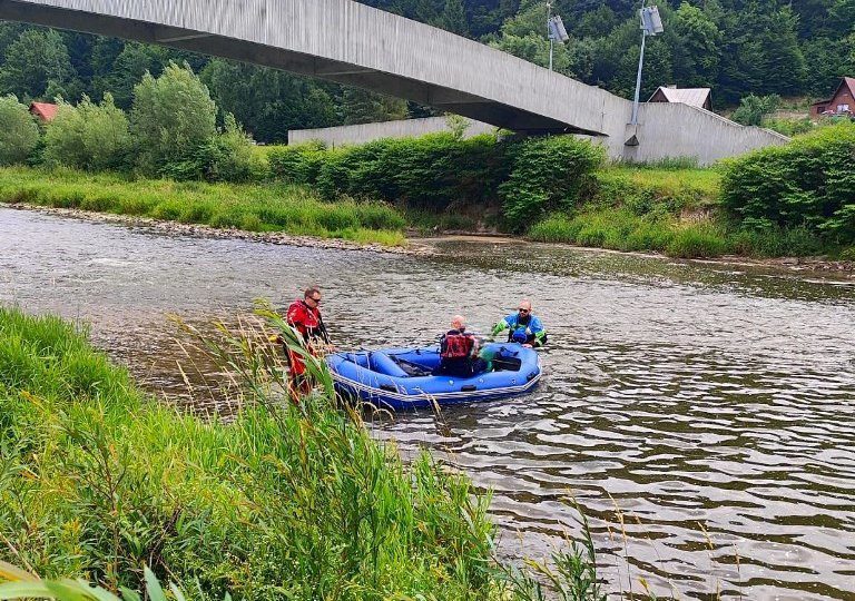 Rzek, na niej ponton niebieski i trzech ratowników