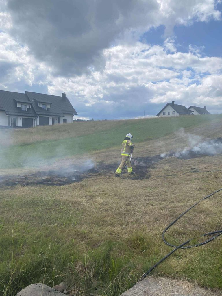 Strażak na poluc gasi płonące siano