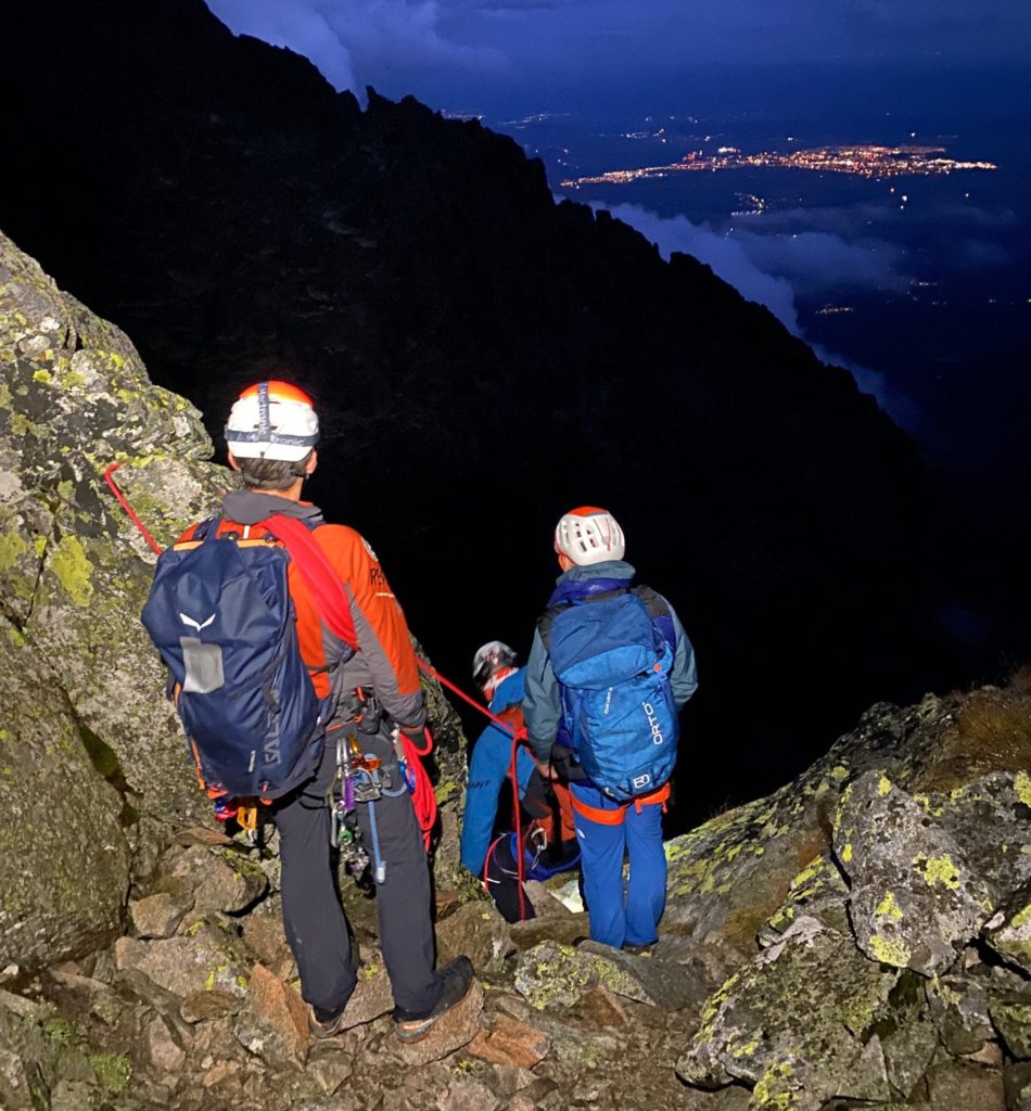 Ratowniyc w górach, noc w oddali światła miasta