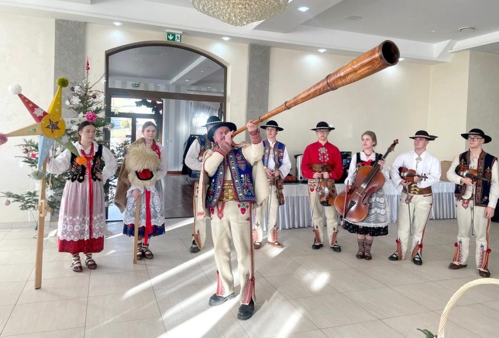 Kapela „Śmiałki” kolędująca z gwiazdą betlejemską i tradycyjnymi instrumentami podczas Gminnej Wigilii dla Seniorów w Krościenku nad Dunajcem.