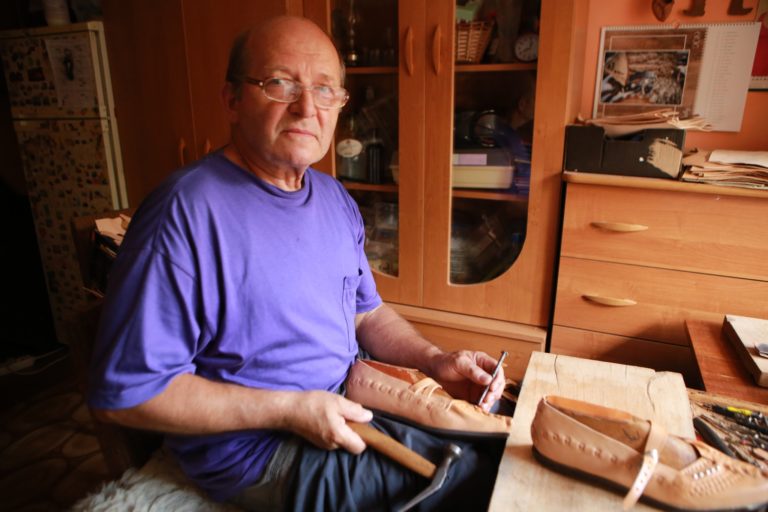 Mistrz kierpców Józef Ligas tworzy ręcznie obuwie ludowe w regionalnym warsztacie.