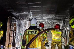 Strażacy w stojach bojowych podczas akcji gaszenia poddasza