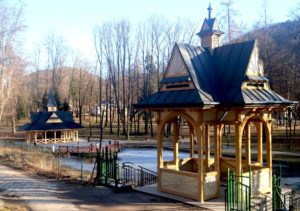 Odnowiona zabytkowa altana widokowa w Park Dolny w Szczawnicy po renowacji – drewniana konstrukcja z ozdobnymi detalami i kamiennymi schodami w otoczeniu zieleni.